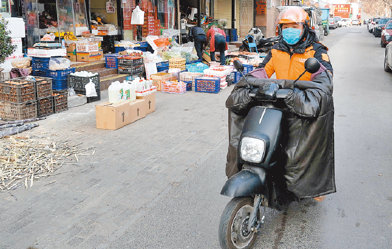 2月25日,鄭州市的跑腿小哥代買完食物和生活用品後騎車送貨。 (新華社)