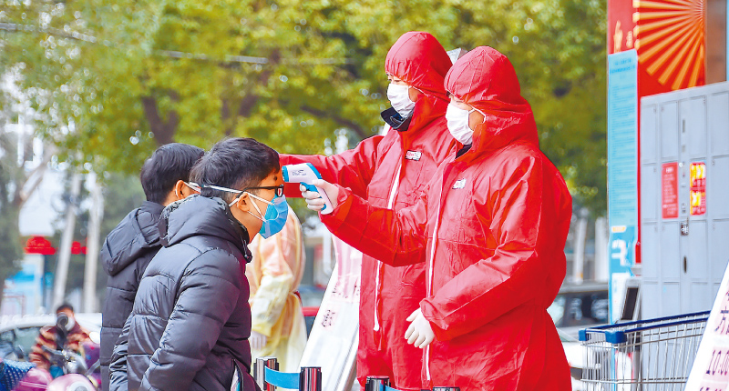 湖北孝感市民在進超市購物前接受體溫檢測。(新華社資料照片)