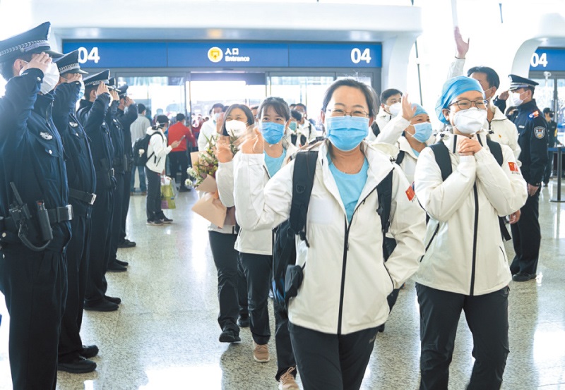 3月17日,天津一救援隊準備從武漢天河機場搭機回家。圖為警察向救援隊隊員敬禮告別。(新華社)