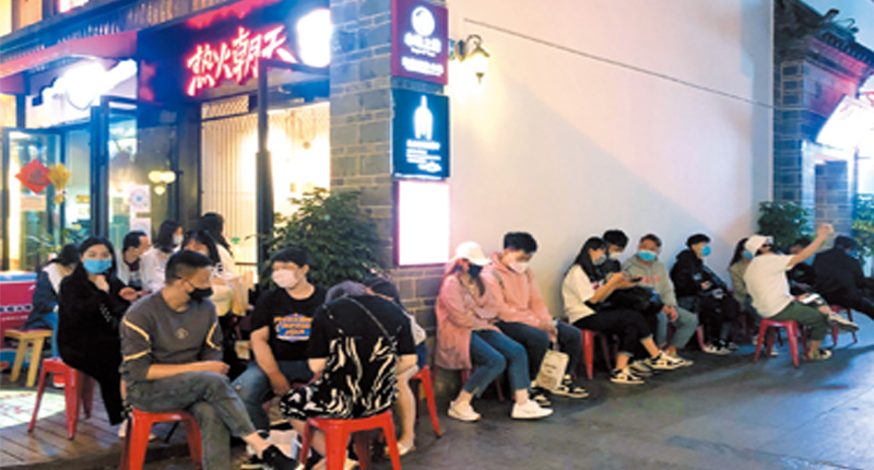 3月15日,消費者在昆明市南強步行街一家「網紅」火鍋店外排隊。(新華社)