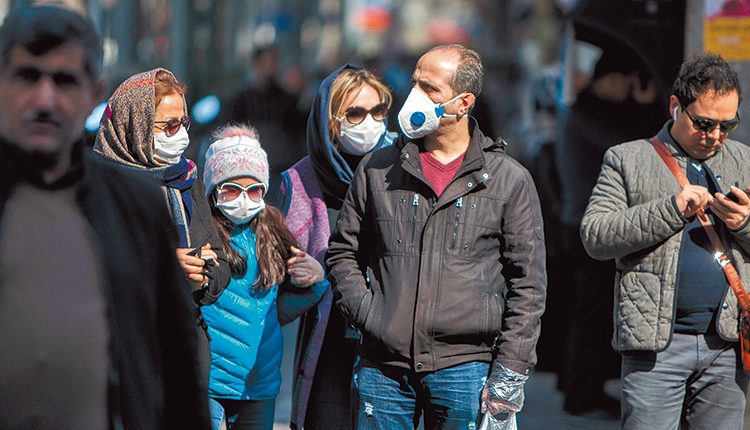 2月23日，伊朗首都德黑蘭，市民戴著口罩出行。（新華社）