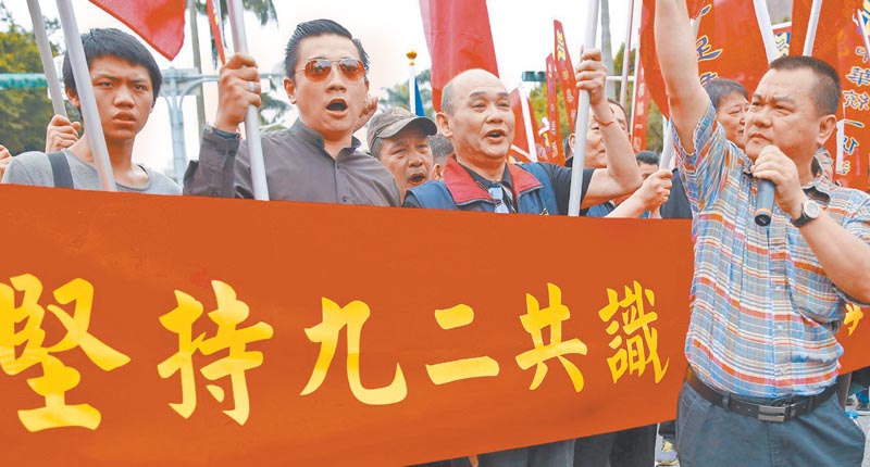 國民黨新任黨主席江啟臣致詞時並未提到「九二共識」。圖為2016年5月,台灣遊行民眾舉著「堅持九二共識」標語。(中新社資料照片)