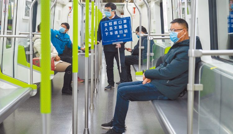 武漢地鐵上，「隨車安全員」提醒乘客記得掃碼、全程戴好口罩。（新華社資料照片）