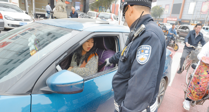 ▲交警攔停車輛,提示駕駛員系安全帶。(中新社資料照片)