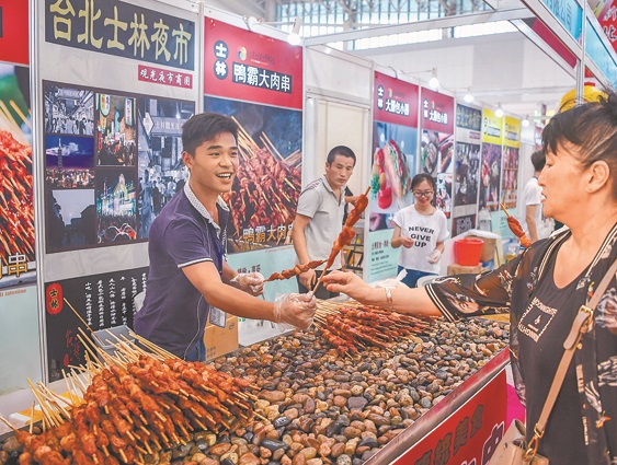 民眾在天津.台灣商品博覽會上品嘗台灣小吃。(新華社資料照片)