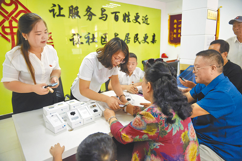 多數智慧手機均支援北斗功能。圖為河北廊坊結合北斗系統,為老人發放定位手環和智慧手機。 (新華社)