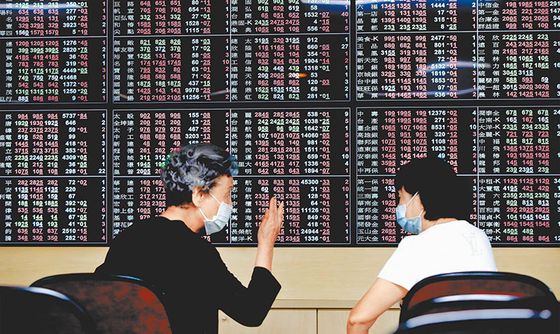 台灣人熱衷股票投資。圖為台股大漲開心討論的投資人。 (本報系資料照片)