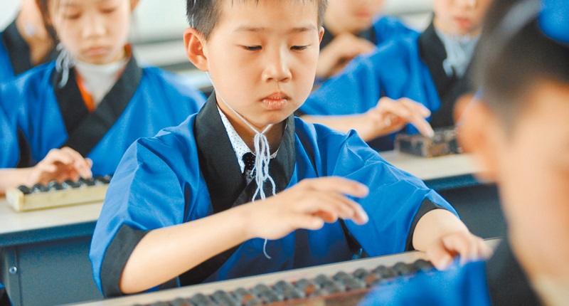 江西省婺源縣紫陽第二小學五年級的學生,身穿古裝學珠算。(中新社資料照片)