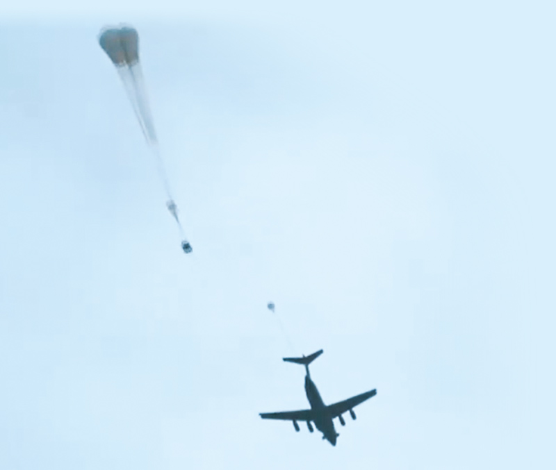 8月底,運-20運輸機在高原空投大型裝備,牽引傘被拋出後綻放傘花。(取自微博@央視軍事)