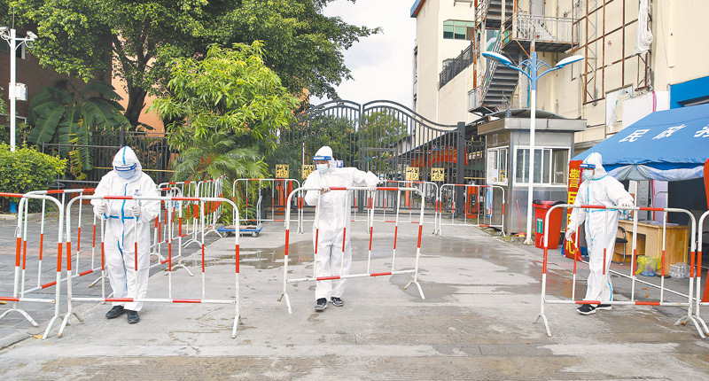 9月15日,工作人員在雲南瑞麗市奧星世紀社區口擺放隔離圍欄。(中新社)