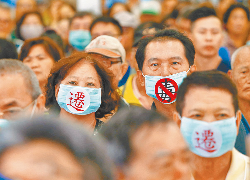 ▲受環境汙染的居民,戴上「遷」和「反毒」口罩表達心聲。(本報系資料照片)
