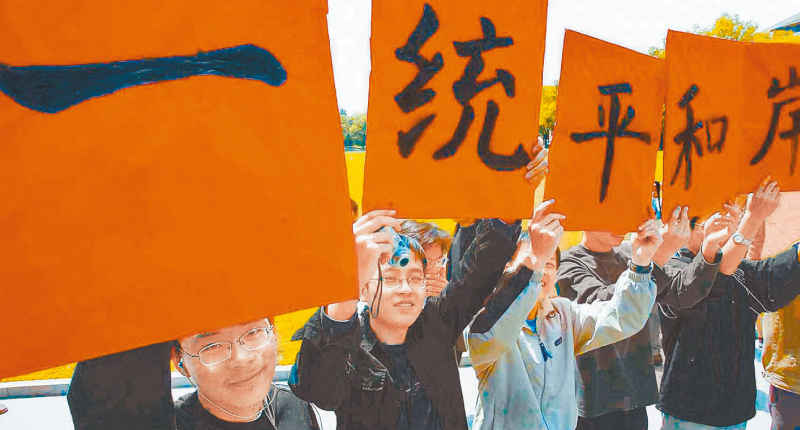 大陸仍維持「和平統一」既定方針。圖為北京清華大學學生,高舉「兩岸和平統一」標語。(本報系資料照片)