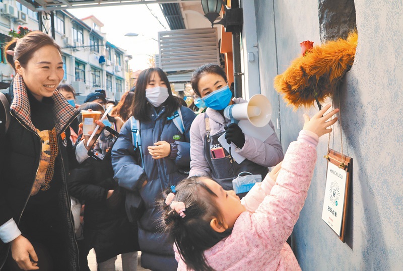 12月6日,民眾排隊購買「熊爪」咖啡,一名小孩與店員透過洞口互動。(中新社)