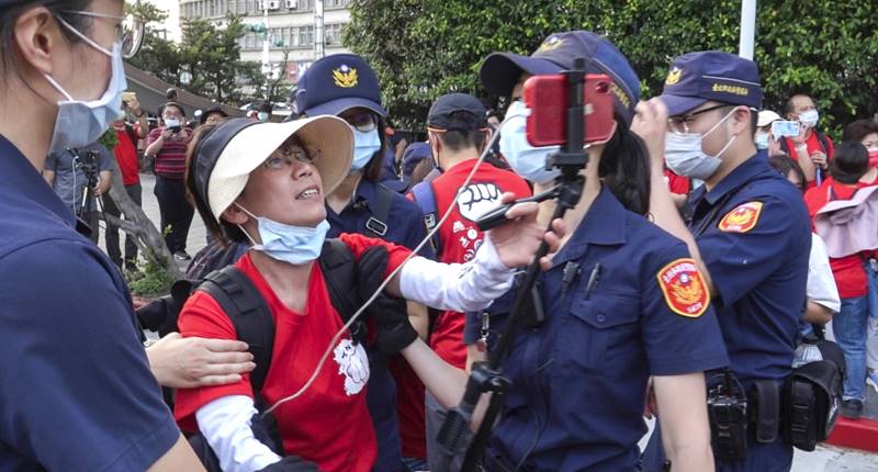 邱儷萍(中)去年5月1日隨同全教總前往行政院要求教師調薪法制化,負責活動記錄及直播的她,最後遭警方強制驅離,仍然持續直播到最後一秒鐘。(黃子明攝)