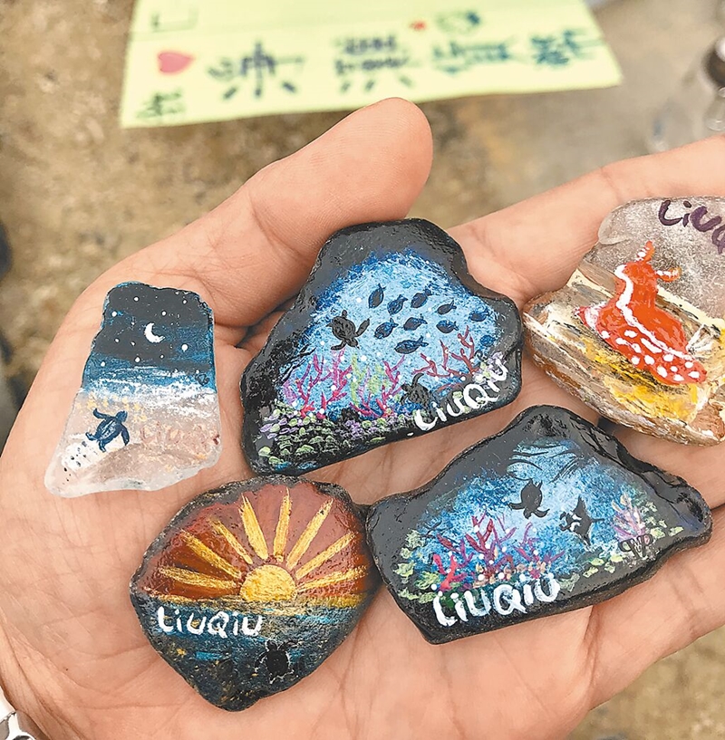 林佩瑜將海漂廢棄玻璃畫上各式海底生物、製成小琉球特有的「海灘貨幣」,一炮而紅。(謝佳潾攝)